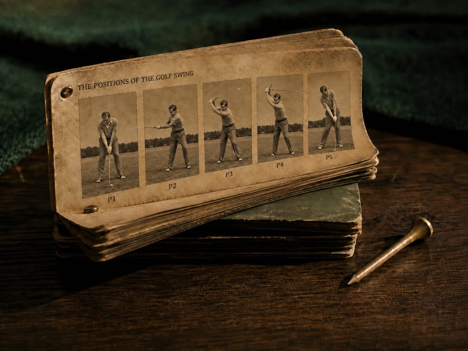 A golf swing flip book, open to a row of sepia frames labelled P1 through P5, resting on a second closed book beside a brass tee.